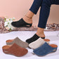 Vylos comfortable wedge mules with perforated floral uppers in black, cream, brown, khaki, and blue, shown on a model's foot with multiple colors displayed.