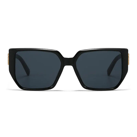 Oversized square Vyrza sunglasses in black acetate with dark grey lenses and distinctive geometric gold-tone metal temple embellishments.