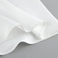 Close-up view of the crisp white matte fabric from an elegant two-piece set, showcasing smooth texture, delicate stitching, and soft pleats.
