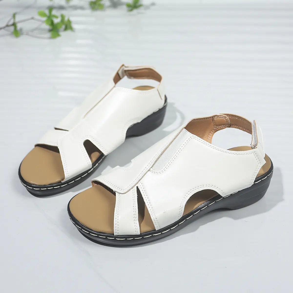 White faux leather platform wedge sandals with a peep-toe design, elastic gore vamp strap, and adjustable ankle buckle strap, shown from a three-quarter studio angle.