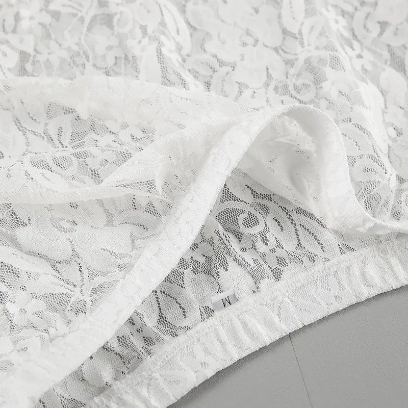 Close-up of intricate white floral lace fabric from a maxi skirt, showcasing the delicate pattern and sheer texture.