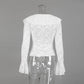 Back view of a white long-sleeved lace blouse featuring a ruffled collar and dramatic flared bell sleeves, showcasing intricate floral patterns and sheer texture.