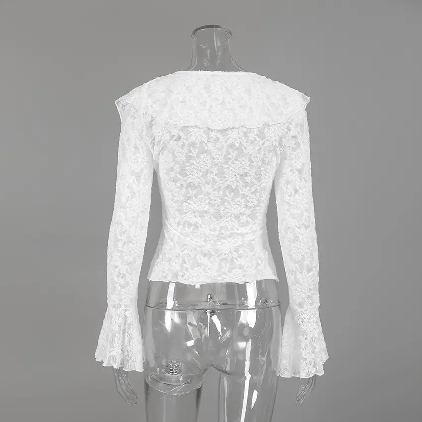 Back view of a white long-sleeved lace blouse featuring a ruffled collar and dramatic flared bell sleeves, showcasing intricate floral patterns and sheer texture.