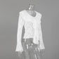 A white sheer floral lace blouse featuring a V-neckline with a cascading ruffle front and dramatic flared bell sleeves, displayed on a clear mannequin against a studio grey background.
