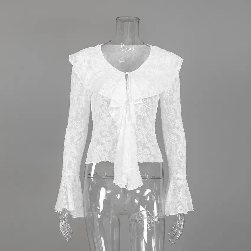 White long-sleeved lace blouse with intricate floral pattern, V-neckline, cascading ruffles, and dramatic bell sleeves, displayed on a mannequin.