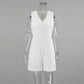 White sleeveless V-neck linen-blend romper with a button-down front, dual chest pockets, and decorative stitching on hip pockets, presented on a mannequin.