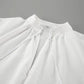 Close-up view of a white linen blend top's V-neckline featuring delicate drawstring ties and gathered fabric details.