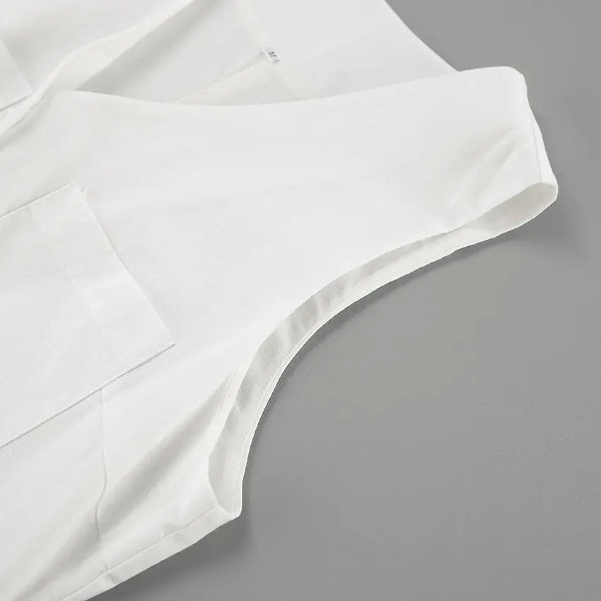 Close-up view of a white linen-blend romper, showcasing the sleeveless armhole, V-neckline detail, and a functional chest pocket with visible stitching.