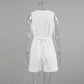 Back view of a white sleeveless linen-blend romper featuring a V-neckline, tie waist, and button-down front, displayed on a mannequin.
