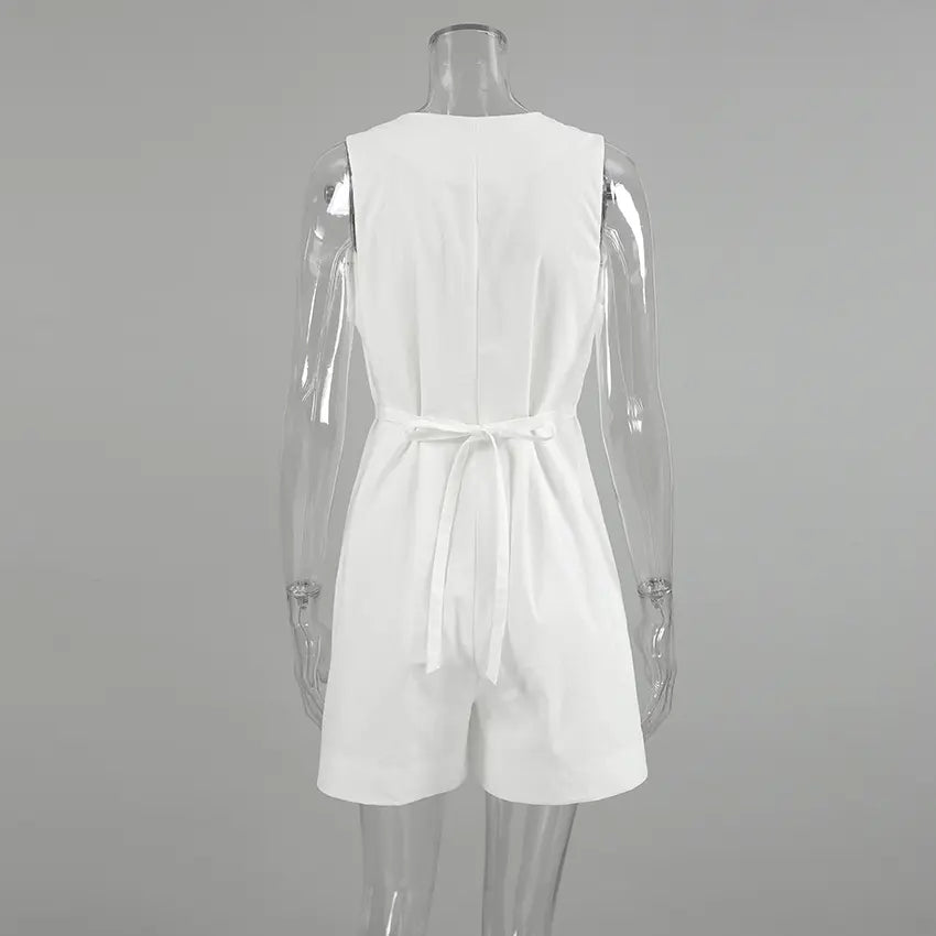 Back view of a white sleeveless linen-blend romper featuring a V-neckline, tie waist, and button-down front, displayed on a mannequin.