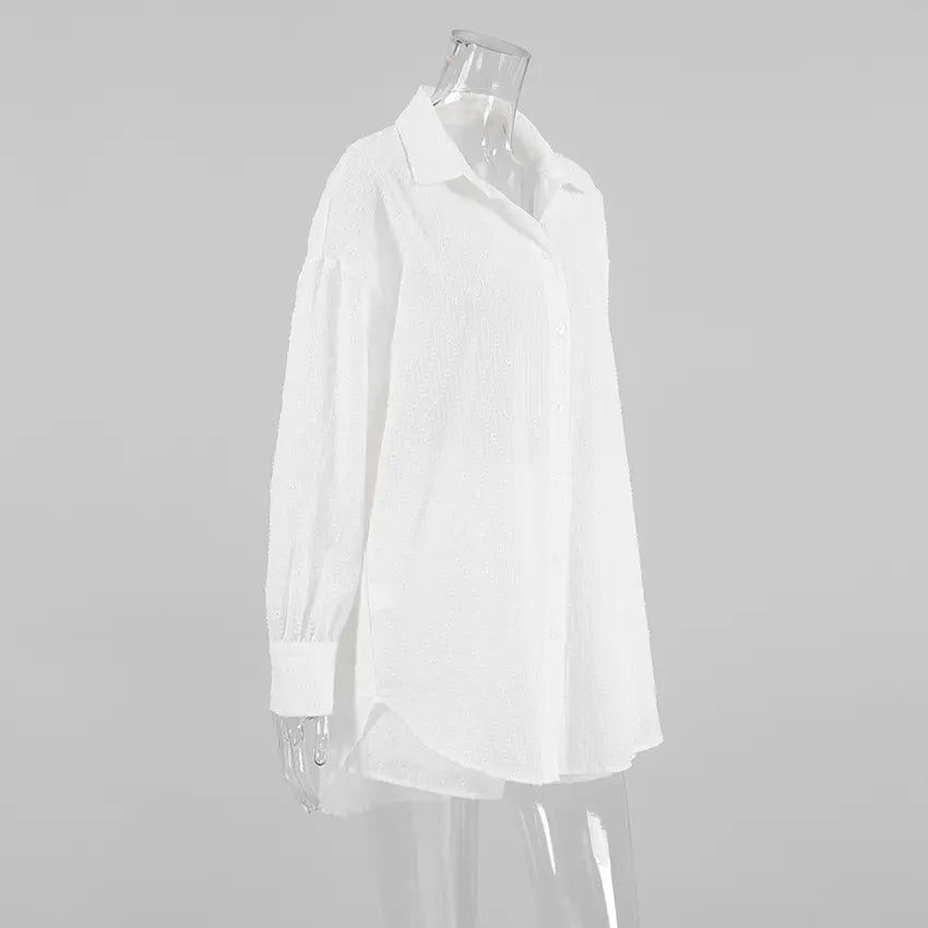 White textured cotton oversized shirt with a camp collar and button-down front, shown from a side view on a mannequin.