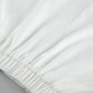 Close-up of the crisp white fabric and elastic waistband of an elegant two-piece set, showcasing the smooth matte texture and refined craftsmanship.