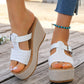 White woven platform espadrille wedge sandals worn by a model with distressed denim jeans and a turquoise anklet, featuring an open toe and adjustable buckle strap.