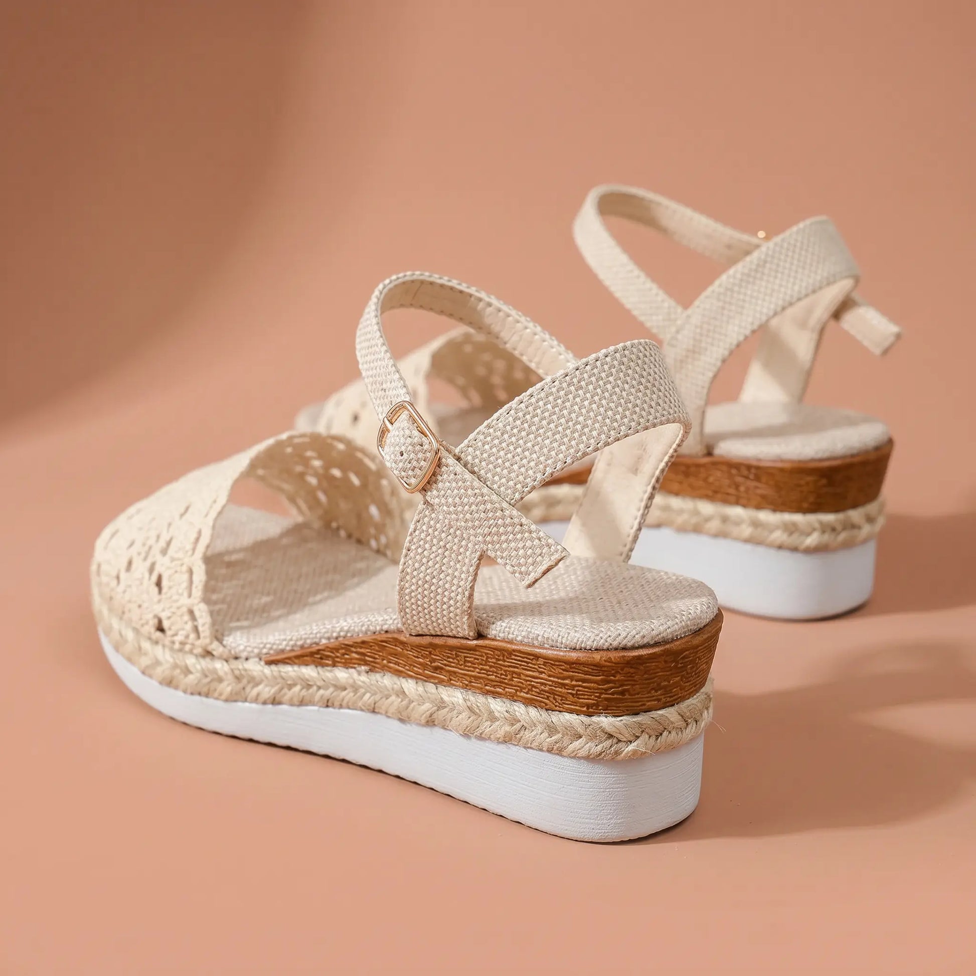 Side view of women's warm beige espadrille wedge sandals featuring intricate crochet lace vamp, jute-wrapped wedge heel, and ankle strap with gold buckle.