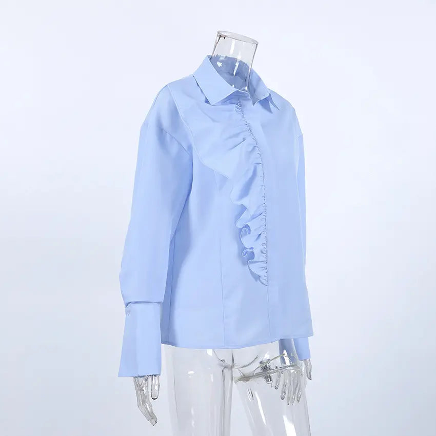 Powder blue women's long-sleeved collared blouse with an asymmetrical ruffle cascade down the front placket, shown on a mannequin in a studio setting.