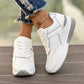 Women's off-white wedge sneakers with textured knit panels, subtle rose gold metallic accents, and a layered white and grey sole, shown from a three-quarter angle with ripped jeans.