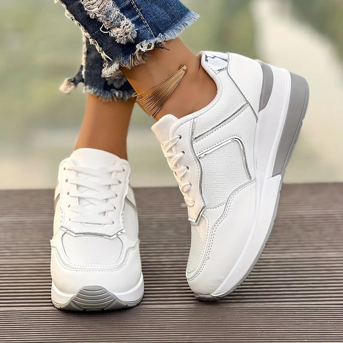 Women's off-white wedge sneakers with textured knit panels, subtle rose gold metallic accents, and a layered white and grey sole, shown from a three-quarter angle with ripped jeans.
