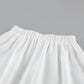 Close-up view of the white A-line midi skirt's elasticated waistband, showcasing the smooth matte fabric texture and clean tailoring detail.