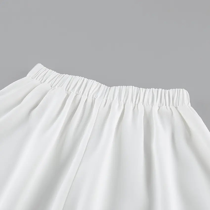 Close-up view of the white A-line midi skirt's elasticated waistband, showcasing the smooth matte fabric texture and clean tailoring detail.