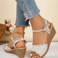 Pale gold embellished Roman wedge sandals worn on feet with distressed denim jeans, featuring peep-toe fronts, delicate sequined embroidery, and adjustable ankle straps.