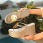 Two Xanthi metallic gold platform wedge sandals shown from the side, featuring a textured woven wedge, thin straps, and a large polished gold disc embellishment.