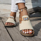 Close-up lifestyle shot of Xylia embellished flat slide sandals in Ivory Cream, featuring a sparkling butterfly embellishment and comfortable cork footbed, worn on feet with white pants and an anklet.