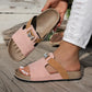 Xylia blush pink embellished flat slide sandals shown on a model's foot, featuring a sparkling butterfly detail and comfortable cork footbed.