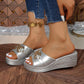 Silver Xyloen women's wedge slide sandals with a chunky metallic chain detail, peep-toe design, and textured wedge heel, styled with blue jeans.