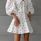 White cotton-linen blend midi dress featuring a playful red heart print, dramatic puff sleeves, a pointed collar, and a button-down front.