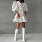 Xylos heart print puff sleeve dress, featuring a crisp pointed collar, A-line silhouette, and button-down front, showcased on a model in white boots against a grey textured studio backdrop.