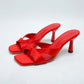 Elegant red Xylos square-toe stiletto sandals featuring a thong toe post and crossed straps with a knot detail, presented on a clean white studio background.