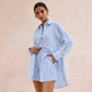 Woman modeling a Xylos textured cotton set in pale sky blue, featuring an oversized camp collar shirt and relaxed-fit shorts, against a blush pink background.