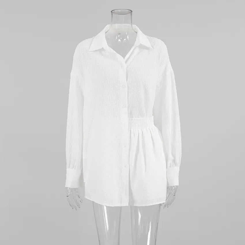 White Xylos textured cotton shirt and shorts set, featuring an oversized relaxed-fit shirt with a camp collar and elasticated-waist shorts. The subtle dot weave fabric offers a breathable, elegant bohemian style for summer.