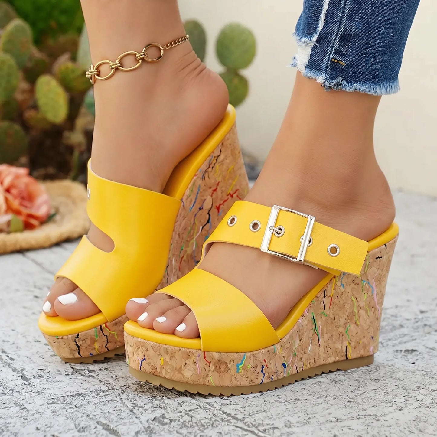 Vibrant yellow peep-toe wedge sandals with a cork-effect platform and colourful paint splatters, featuring an adjustable silver buckle ankle strap.