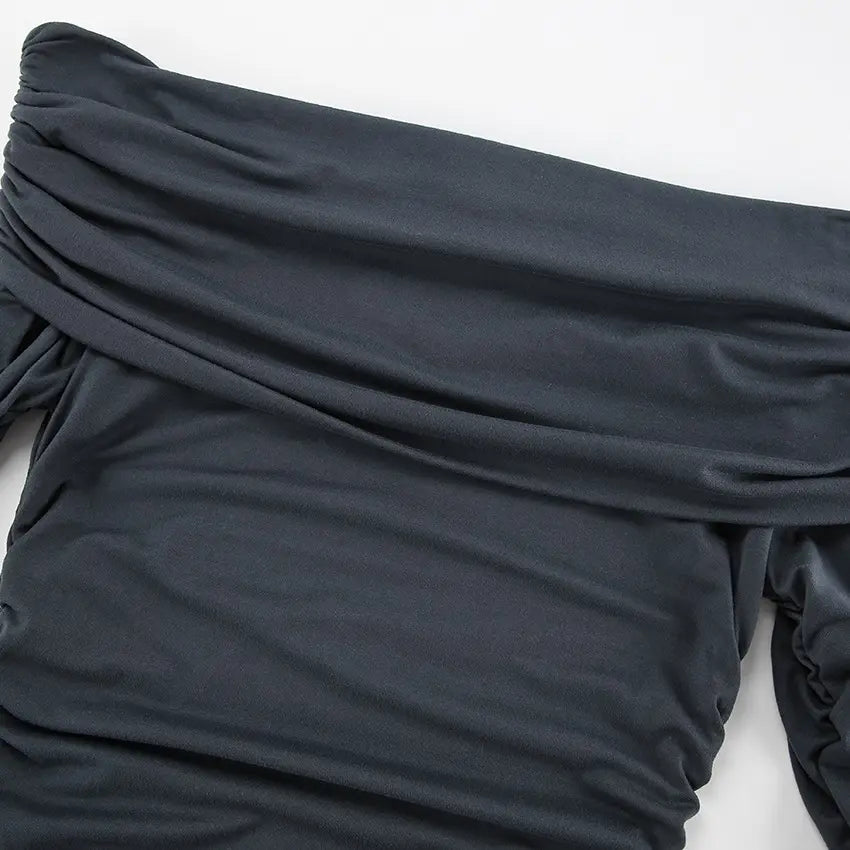 Close-up view of a charcoal grey Zavala off-the-shoulder mini dress, showcasing intricate all-over asymmetrical ruching and draped neckline detail.