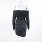 Charcoal grey off-shoulder long-sleeved ruched mini dress displayed from the back on a clear mannequin. Features intricate all-over draping and a form-fitting silhouette.