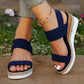 Zaylin navy blue espadrille wedge sandals worn on feet with a gold-tone ankle chain, showcasing elasticated straps and a peep-toe design against a natural outdoor backdrop.