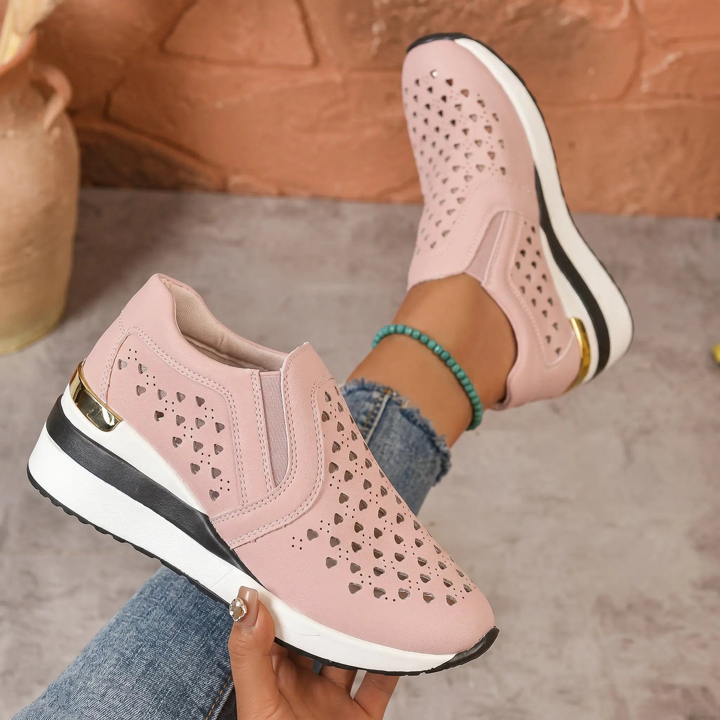 Zayna women's dusty rose perforated heart wedge loafers shown on foot, offering a blend of bohemian charm and elegant comfort with a gold heel accent.