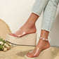 Women's Zelka clear strap wedge sandals with woven espadrille sole, shown on feet wearing light wash jeans with pearl anklet. Summer bohemian style.