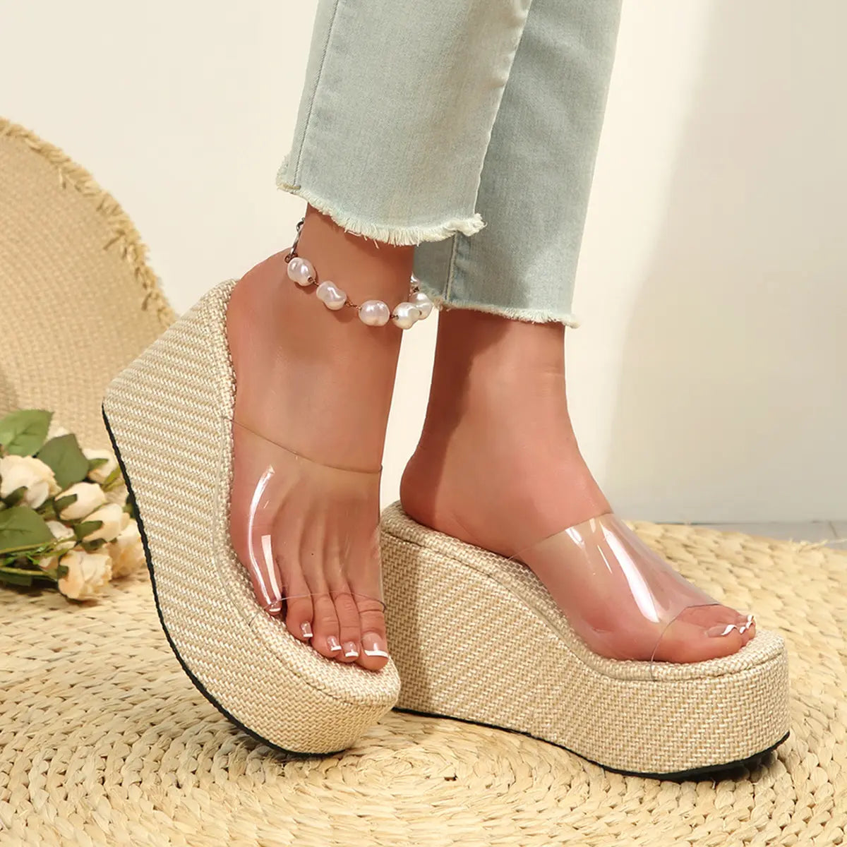 Women's Zelka clear strap wedge slide sandals styled with a woven espadrille sole and platform, shown on a neutral mat with floral accents.