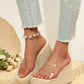 Women's almond beige Zelka wedge slide sandals with clear PVC straps and a woven espadrille sole, styled with light wash jeans and a pearl anklet.