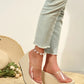 Zelka clear strap wedge sandals with a woven espadrille sole and platform toe, styled with light blue jeans and a pearl anklet on a woven mat with a straw hat and flowers.