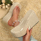 Women's Zelka clear strap wedge sandals with natural woven espadrille sole, worn on a foot with a pearl anklet, styled on a woven mat with subtle floral background.