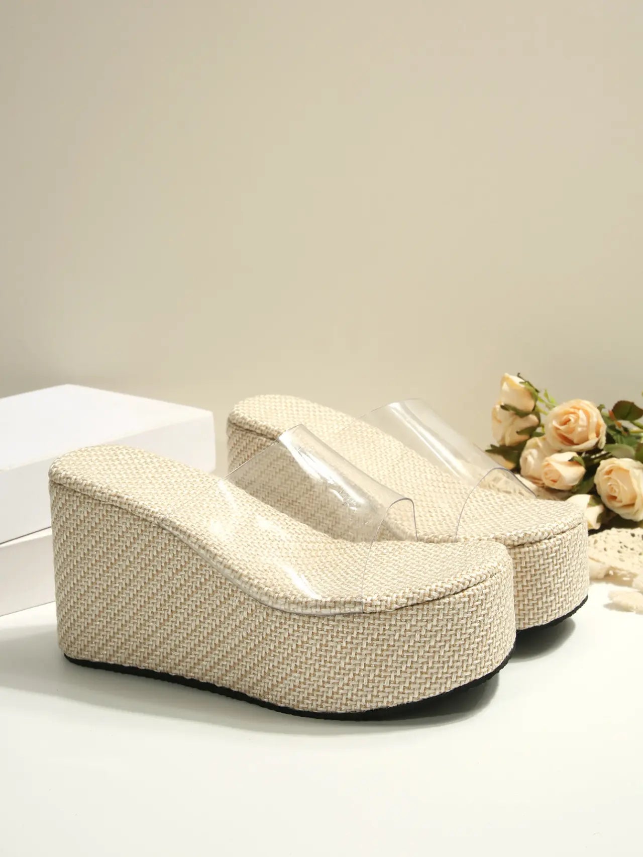 Zelka women's wedge slide sandals featuring transparent PVC straps and a natural beige espadrille-wrapped wedge sole with a platform toe. This image shows a three-quarter view of the summery footwear.