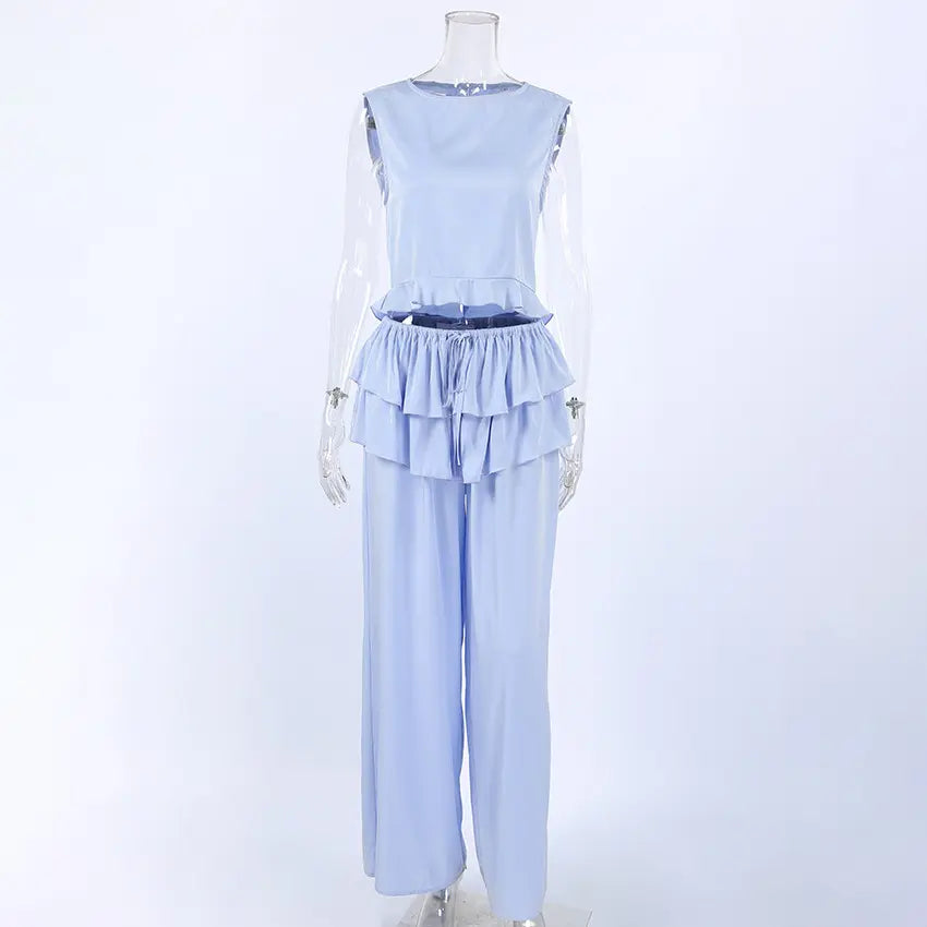 Zelphira Elegant Bohemian Set in soft lilac-blue, featuring a sleeveless ruffled crop top and flowing wide-leg trousers displayed on a mannequin. This sophisticated two-piece outfit embodies chic, romantic style.
