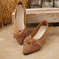 Zendari elegant pointed-toe knit flats in bronze with a shimmering metallic thread and a delicate bow accent, shown from three-quarter and side views on a textured surface with rustic background elements.