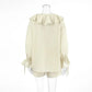 Back view of the Zephyrine ivory cream boho ruffle two-piece set, featuring a loose-fitting blouse with long balloon sleeves and elasticated tie cuffs, paired with high-waisted drawstring shorts.