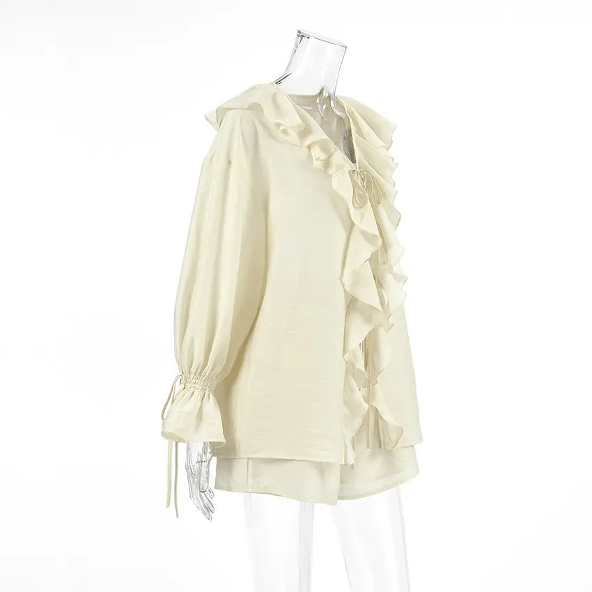 Side view of an ivory cream Zephyrine boho ruffle summer set, featuring a loose-fitting blouse with balloon sleeves and tiered ruffles, paired with high-waisted shorts.