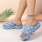 Women's Zevon distressed denim checkerboard platform slides, showcasing frayed edges and a thick layered sole on a light peach background with a palm frond accent. This lifestyle image highlights the bohemian summer sandal style.