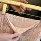 Close-up of the Zhalis high-waisted floral maxi skirt showing the gathered elastic waistband, sheer ditsy floral chiffon, and smooth pink satin lining.